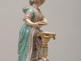 a figurine of a woman standing at a table