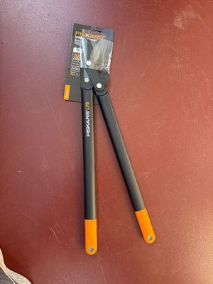 pair of black and orange pliers laying on top of a brown table