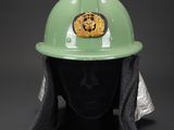a green helmet with a gold badge on it