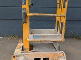 a close up of a yellow scissor sitting on top of a parking lot
