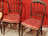three antique chairs with red upholstered cushions against a red wall