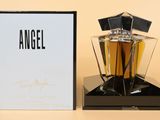 an angel perfume bottle sitting next to a box on a table