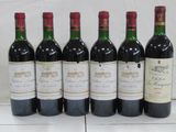 six bottles of wine are lined up on a table