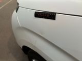 a close up of a white car with a sticker on it