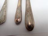 three spoons and a fork on a white table