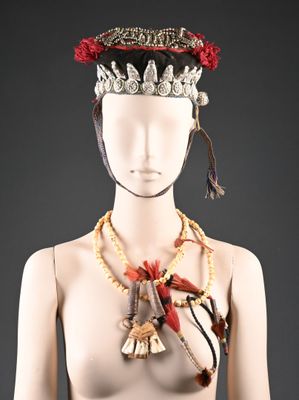 une image représentant un mannequin portant une coiffe faite de perles et de plumes