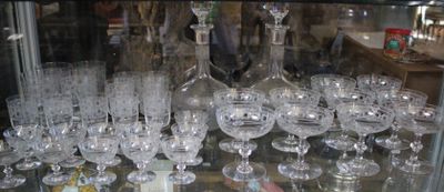 a glass display case filled with wine glasses in a store