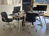 des tables et des chaises dans une pièce dotée d'une grande fenêtre et d'une affiche accrochée au mur