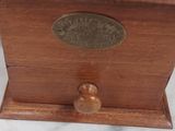 a small wooden box with a metal lid on a table