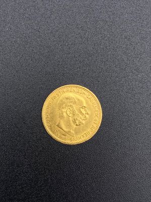 a gold coin on a black surface