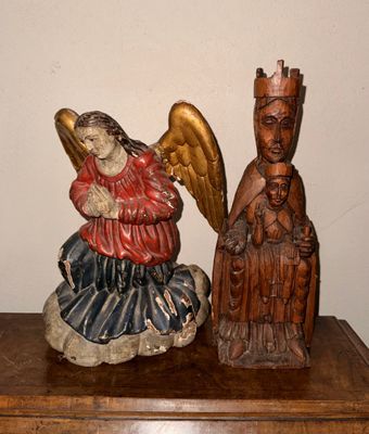 une statue d'ange et une statue d'homme posées sur une table