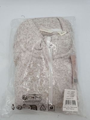 un pull blanc dans un sac en plastique posé sur une table