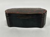 a black and red box with a lid on a white surface