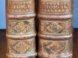 deux vieux livres posés l'un à côté de l'autre sur une table en bois