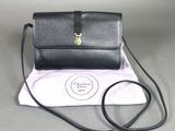 un petit sac à main noir muni d'un fermoir doré