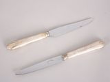 pair of silver plated knives on a white background