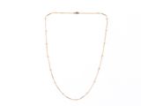 a gold chain necklace with pearls on a white background