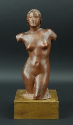 une photo d'une statue en bronze représentant une femme, posée sur un socle en bois