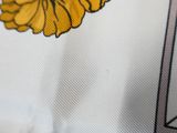 a close up of a yellow flower on a white shirt