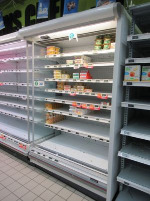 many empty shelves in a store with food on them
