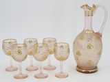 des bouteilles et des verres sont alignés à côté d'un pichet et de verres