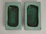these are two green dishes with a green rim on a white table