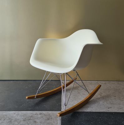 a white rocking chair in a room with a black and white checkered floor