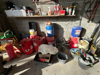 un garage où s'entassent de nombreux objets et outils par terre