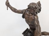 a statue of a boy holding a torch in his hand