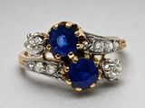 une photo d'une bague sertie d'un saphir bleu et de diamants, posée sur une surface blanche