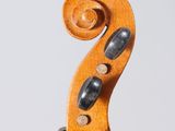 a close up of a violin neck with a fiddle in the background