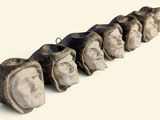 a long row of stone heads with faces on them