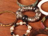 many different bracelets on a wooden table together