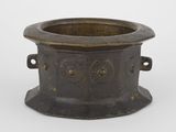 un vieux pot en bronze muni d'anses, sur fond blanc