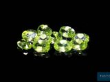 a close up of a group of green gems on a black surface