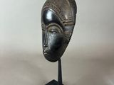 a black sculpture of a woman ' s face on a black stand