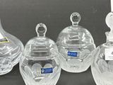 three clear glass vases and a glass decanter on a table
