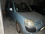 a small blue van parked in a parking garage