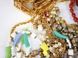 a lot of different necklaces and bracelets on the table
