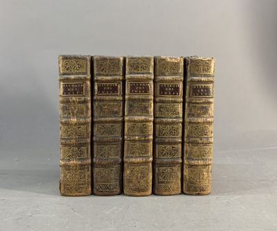 six vieux livres empilés les uns sur les autres sur une surface blanche