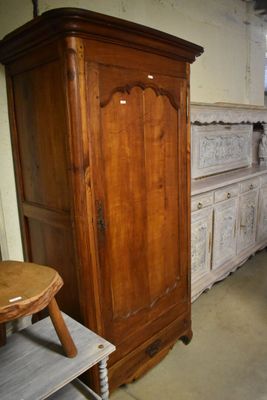 une armoire en bois dans un coin de la pièce, à côté d'une table