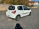 a small white car that is parked in a parking lot