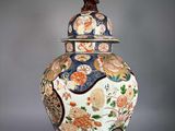 a vase with a lid that has flowers and birds on it