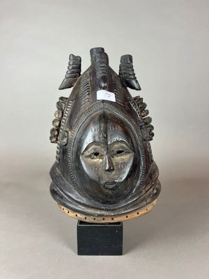 un gros plan d'un masque en métal posé sur un support, sur une table