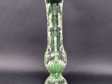 a green vase that is sitting on a black table