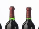 six bouteilles de vin sont alignées sur une table