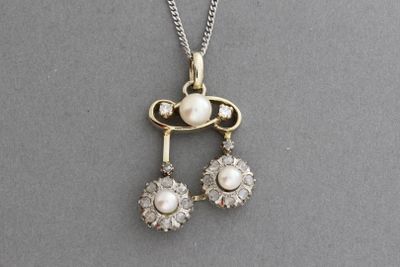 un gros plan sur un collier orné de deux perles