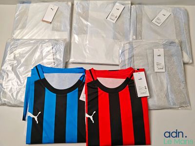 several soccer shirts are sitting on a table in plastic bags