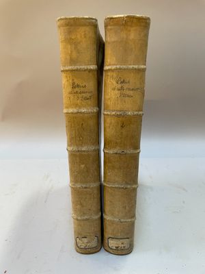 deux vieux livres posés l'un sur l'autre sur une surface blanche
