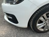 a close up of a white car parked on the side of the road